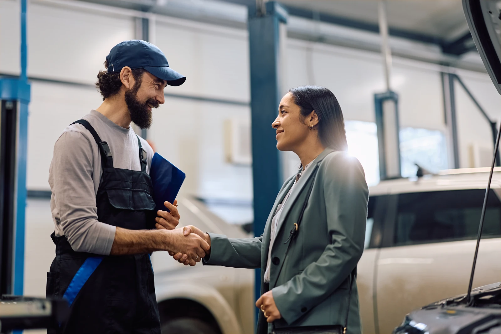 Cliente e profissional de um centro automotivo apertando as mãos
